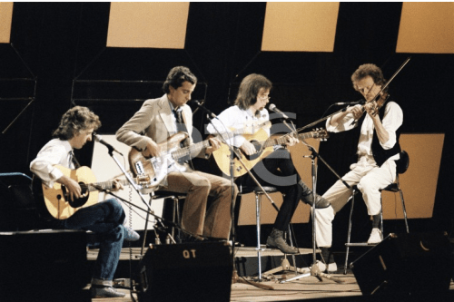 Hotfoot on stage at the National Stadium in September 1983. From left to right; Jimmy Faulkner on acoustic guitar, Declan McNelis on bass guitar, Jimmy Gibson on acoustic guitar and violinist Pat Collins. This concert was recorded and televised as part of RTÉ Television's 'Festival Folk' series on 14 March 1984. Credit - stillslibrary.rte.ie
