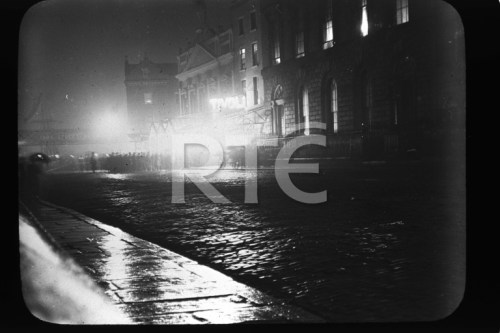 "A night shot of people gathered outside the Tivoli Theatre on Dublin's Burgh Quay, circa 1920. The White Horse Inn can be seen in the background. Credit - RTE